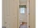 Narrow bathroom featuring white cabinets, tiled floor and wallpapered walls with a window for natural light at 212 Garret Rdg, Peachtree City, GA 30269