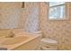 Cozy bathroom featuring a toilet, single sink vanity, and a window dressed in wallpaper at 212 Garret Rdg, Peachtree City, GA 30269