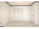 Bedroom featuring wallpaper, bi-fold closet doors, and neutral carpeting at 212 Garret Rdg, Peachtree City, GA 30269
