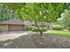Home exterior with a long driveway, two-car garage, and a beautiful tree at 212 Garret Rdg, Peachtree City, GA 30269