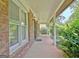 Covered porch with brick columns, outdoor lighting, and leafy landscaping at 212 Garret Rdg, Peachtree City, GA 30269