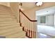 Carpeted staircase with a wooden railing leads to a bright living area at 212 Garret Rdg, Peachtree City, GA 30269
