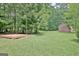 Tree-lined backyard with mature trees, shed and platform at 501 Bridlepath Ln, Peachtree City, GA 30269
