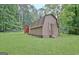 Backyard barn with double doors, offering ample storage space and potential for various uses at 501 Bridlepath Ln, Peachtree City, GA 30269