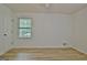 A bright bedroom featuring one window and wood-look floors at 501 Bridlepath Ln, Peachtree City, GA 30269