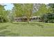 Beautifully landscaped front yard with mature trees surrounding a brick home at 501 Bridlepath Ln, Peachtree City, GA 30269