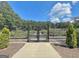 Entrance to the garden behind an iron gate offers a tranquil escape surrounded by lush greenery at 501 Bridlepath Ln, Peachtree City, GA 30269