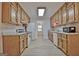 Galley kitchen featuring wooden cabinets, granite counters, white appliances, and vinyl flooring at 501 Bridlepath Ln, Peachtree City, GA 30269