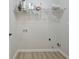Bright laundry room with shelving, connections and light wood flooring at 501 Bridlepath Ln, Peachtree City, GA 30269