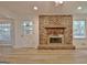 Bright living room features a brick fireplace, new floors, and a back door leading to a sunroom at 501 Bridlepath Ln, Peachtree City, GA 30269
