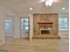 Bright living room features a brick fireplace, new floors, and a back door leading to a sunroom at 501 Bridlepath Ln, Peachtree City, GA 30269