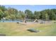 Well-maintained playground and tennis court nestled in a lush green space is surrounded by trees at 501 Bridlepath Ln, Peachtree City, GA 30269