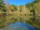 Reflections on the calm pond surface surrounded by colorful autumn foliage and trees at 501 Bridlepath Ln, Peachtree City, GA 30269