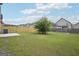 Flat backyard with new fence, green grass, small tree, and patio area at 2493 Oakleaf Rdg, Lithonia, GA 30058