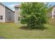 Flat green backyard featuring a mature shade tree and partial fence at 2493 Oakleaf Rdg, Lithonia, GA 30058