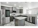 Modern kitchen features stainless steel appliances, gray cabinets, and an island with granite countertop at 2493 Oakleaf Rdg, Lithonia, GA 30058