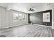 Spacious living room featuring stylish gray wood floors, bright walls, and modern ceiling fan at 2493 Oakleaf Rdg, Lithonia, GA 30058