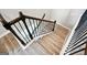 Wooden staircase with black metal railings and white trim, showcasing the transition between floors at 2493 Oakleaf Rdg, Lithonia, GA 30058