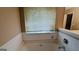 Large bathtub is tiled and under a window for natural light and relaxation at 3679 Seabass Rd, Decatur, GA 30034