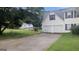 Home with a long driveway leading to a two-car garage, set against a backdrop of mature trees at 3679 Seabass Rd, Decatur, GA 30034