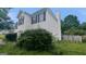Two-story home with white vinyl siding, dark shutters, and overgrown landscaping at 3679 Seabass Rd, Decatur, GA 30034