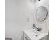 A bathroom featuring white cabinets, round mirror, modern sink, and updated fixtures at 5490 Chemin De Vie, Sandy Springs, GA 30342