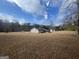 Wide backyard with a house featuring a screened-in porch under a partly cloudy sky at 120 Creekwood Ln, Fayetteville, GA 30214