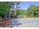 Community basketball court with a picnic table and playground in a wooded area at 135 Edgewater Trl, Fayetteville, GA 30215