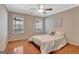 Bright bedroom with hardwood floors and two windows looking out onto a treed landscape at 135 Edgewater Trl, Fayetteville, GA 30215