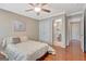 Comfortable bedroom with hardwood floors, a ceiling fan, and a door to an en-suite bathroom at 135 Edgewater Trl, Fayetteville, GA 30215