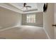 Spacious bedroom features neutral walls, tray ceiling with fan, and window for natural light at 135 Edgewater Trl, Fayetteville, GA 30215