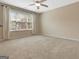 Bright bedroom with neutral carpet, ceiling fan, one window and base molding at 135 Edgewater Trl, Fayetteville, GA 30215