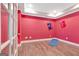 Bright bonus room with laminate wood flooring, and red accent wall at 135 Edgewater Trl, Fayetteville, GA 30215