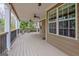 Expansive covered porch with ceiling fans, outdoor seating, and a view of the landscaped yard at 135 Edgewater Trl, Fayetteville, GA 30215