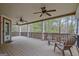 Spacious covered porch with ceiling fans and outdoor seating overlooking a wooded backyard at 135 Edgewater Trl, Fayetteville, GA 30215