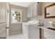 Well-lit laundry room features a washing machine, utility sink, and cabinets for storage at 135 Edgewater Trl, Fayetteville, GA 30215