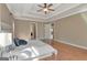 Large main bedroom with hardwood floors, tray ceiling, ceiling fan, and open doorway at 135 Edgewater Trl, Fayetteville, GA 30215