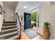 Welcoming foyer with hardwood floors, a staircase, and a front door adorned with a wreath at 108 Summit Walk, Peachtree City, GA 30269
