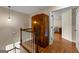 Spacious hallway featuring hardwood floors, vintage cabinet, and door that leads to one of the bedrooms at 108 Summit Walk, Peachtree City, GA 30269