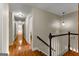 Upstairs hallway with hardwood floors and a staircase with wood railing at 108 Summit Walk, Peachtree City, GA 30269