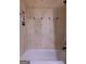 A well-maintained bathroom features neutral tile, decorative wall trim, and a bathtub with a shower at 8035 Magnolia Way, Roswell, GA 30075