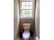 Small toilet room with a standard toilet and a window, offering privacy and ventilation at 8035 Magnolia Way, Roswell, GA 30075