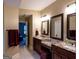 Bathroom featuring a double sink vanity with granite countertops and modern mirrors at 8035 Magnolia Way, Roswell, GA 30075