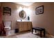 Neutral toned bathroom featuring a toilet, vanity, lighting, mirror, decor and bench at 8035 Magnolia Way, Roswell, GA 30075