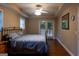 Comfortable bedroom features a ceiling fan, two windows, doors to a patio, and an iron bed frame at 8035 Magnolia Way, Roswell, GA 30075