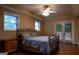 Comfortable bedroom features a ceiling fan, two windows, doors to a patio, and an iron bed frame at 8035 Magnolia Way, Roswell, GA 30075