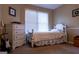 This bedroom has a white dresser, bed frame, and window, offering a clean, and bright space at 8035 Magnolia Way, Roswell, GA 30075
