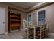 Cozy dining room with a wooden table, white chairs, hutch, and natural light from the window at 8035 Magnolia Way, Roswell, GA 30075