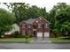 Stately brick home featuring a two-car garage and manicured front lawn at 8035 Magnolia Way, Roswell, GA 30075