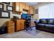 Bright home office with a wooden desk, upper cabinets, comfy sofa, and natural light from the window at 8035 Magnolia Way, Roswell, GA 30075